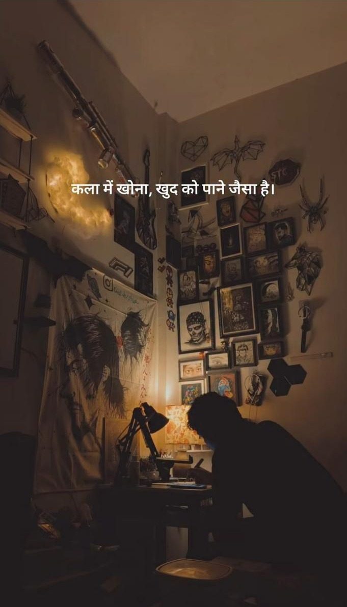 Silhouette of the artist drawing at the desk under a warm lamp
