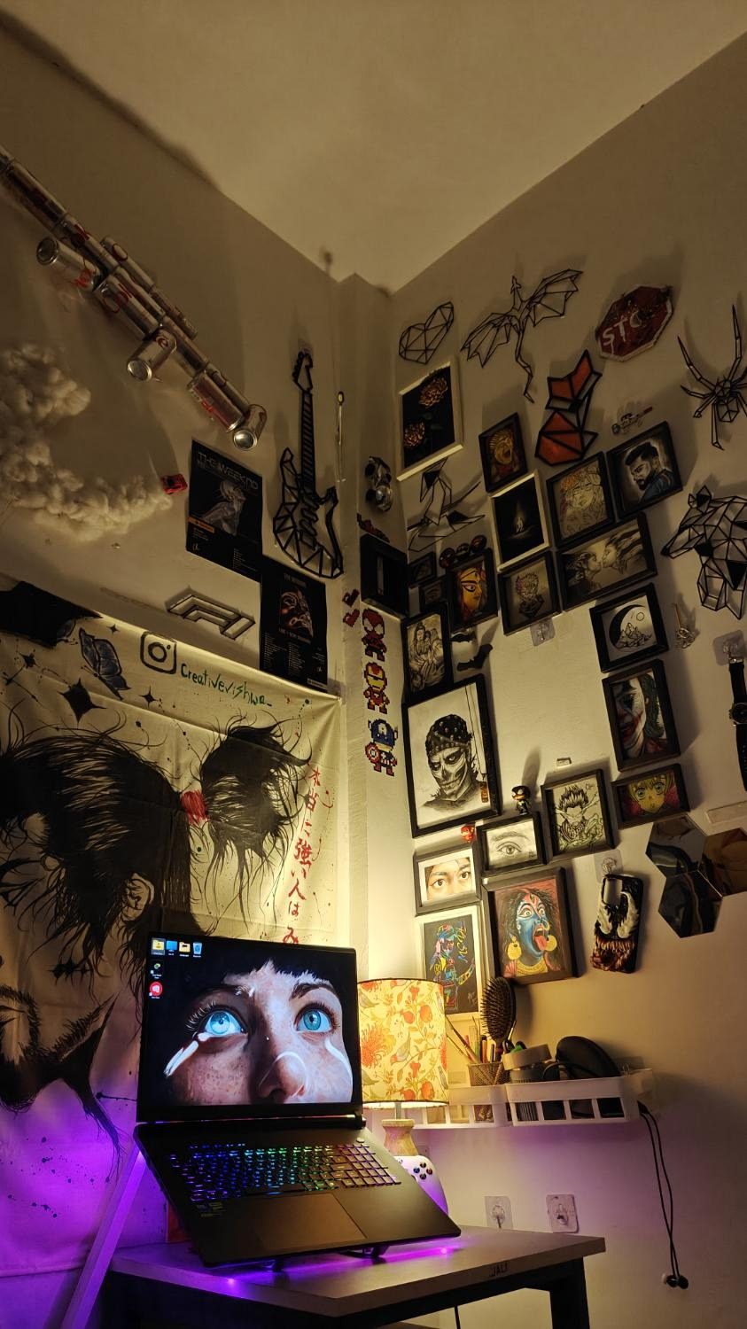 ANKIT studio at night — gallery wall, tapestry, and glowing laptop
